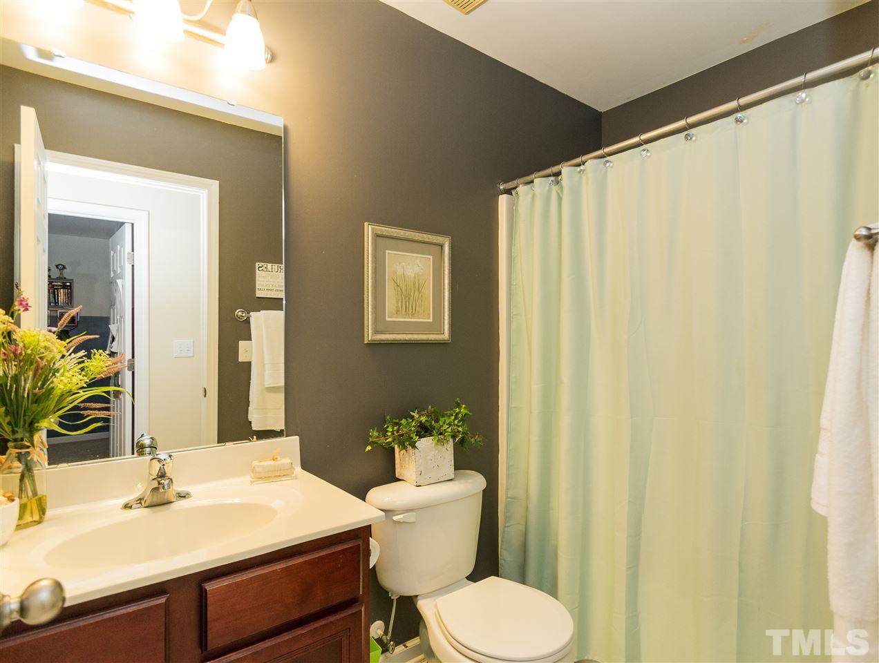 4809 Hodfield Court Raleigh, NC 27604 - Photo 19 of 22 a bathroom with a sink vanity mirror and toilet