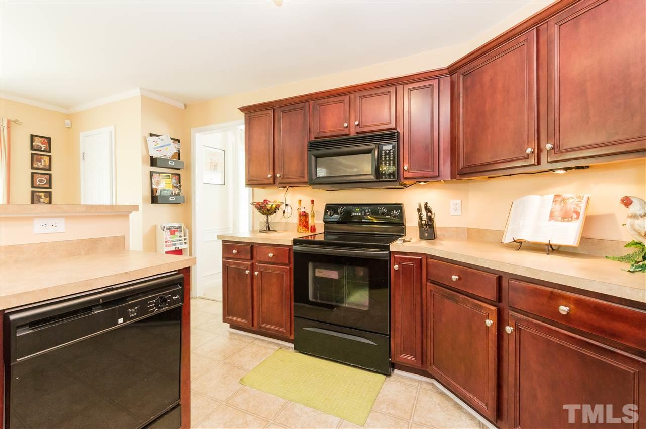 4809 Hodfield Court Raleigh, NC 27604 - Photo 8 of 22 a kitchen with granite countertop wooden cabinets and stainless steel appliances