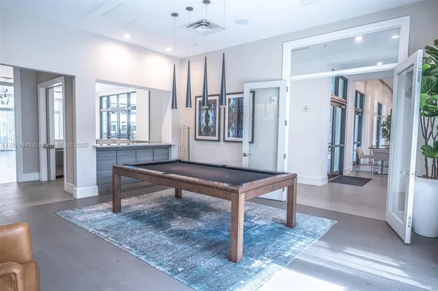 a view of a hallway with windows and chandelier