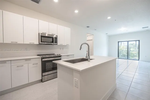 a kitchen with kitchen island a sink stove and refrigerator