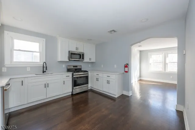 a kitchen with granite countertop white cabinets and white appliances