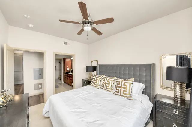 a spacious bedroom with a bed and a dresser