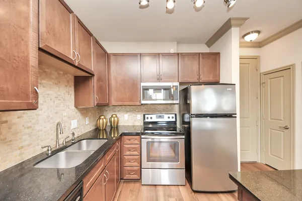 a kitchen with kitchen island a stove a chandelier and a refrigerator