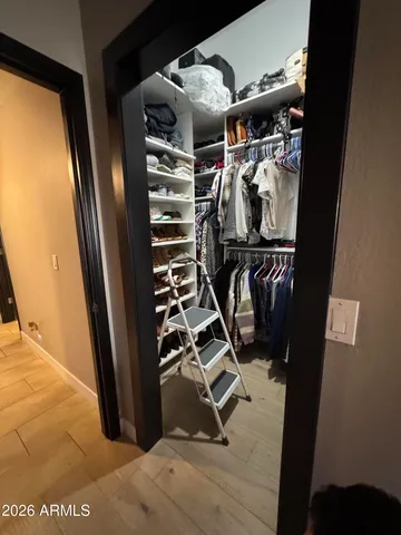 a view of walk in closet with clothes and shoes