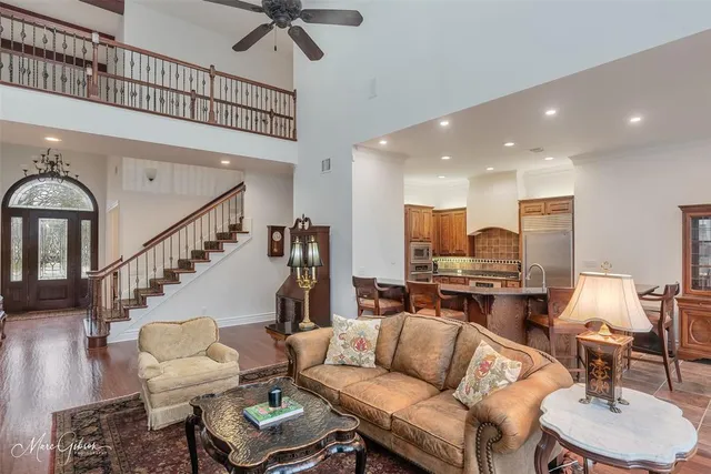 a living room with furniture kitchen view and a wooden floor