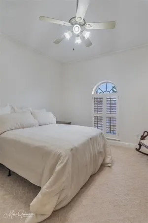 a spacious bedroom with a bed a couch and a ceiling fan