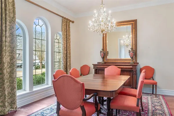 a dining room with furniture a chandelier and wooden floor