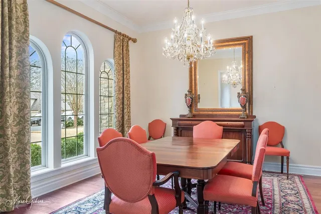 a dining room with furniture a chandelier and wooden floor