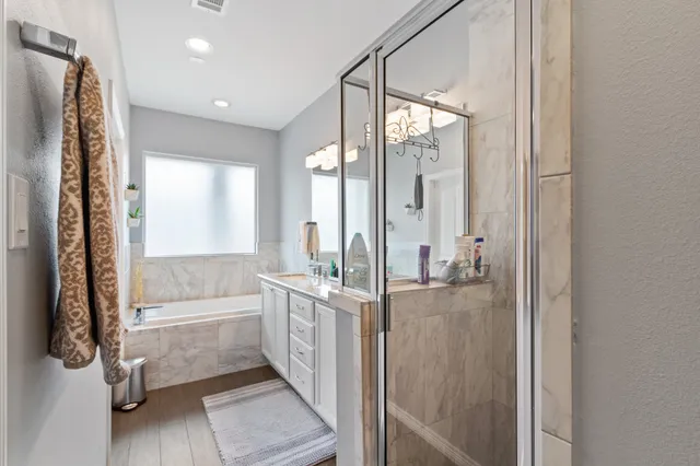 a bathroom with a tub sink shower and mirror