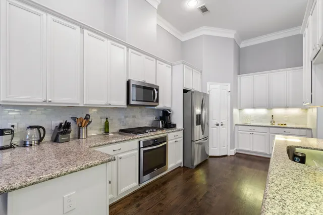 a kitchen with white cabinets and stainless steel appliances