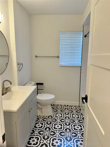 a bathroom with a sink a toilet and a mirror