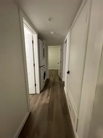 a view of a hallway with wooden floor and a cabinet