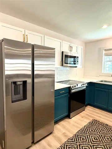 a kitchen with stainless steel appliances kitchen island granite countertop a refrigerator stove and sink