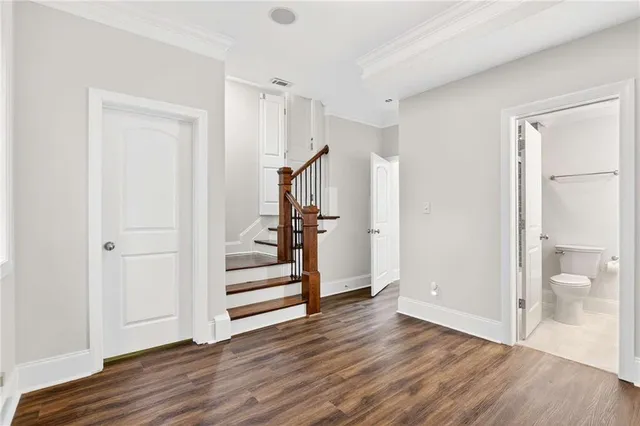 a view of a hallway with wooden floor and entryway