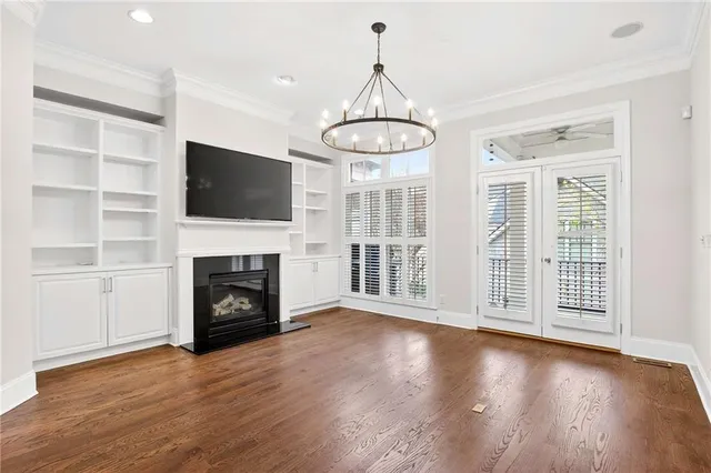 a view of a livingroom with a fireplace wooden shelves and windows