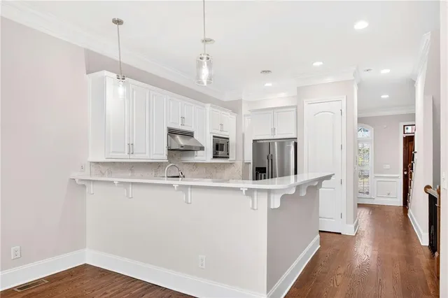 a kitchen with stainless steel appliances a refrigerator and a stove top oven