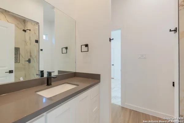 a bathroom with a granite countertop sink and shower