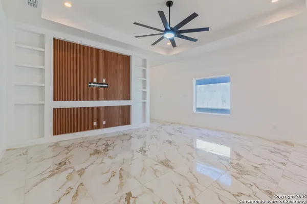 a view of a big room with wooden floor and a ceiling fan