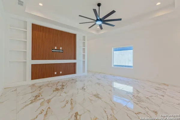 a view of a big room with wooden floor and windows