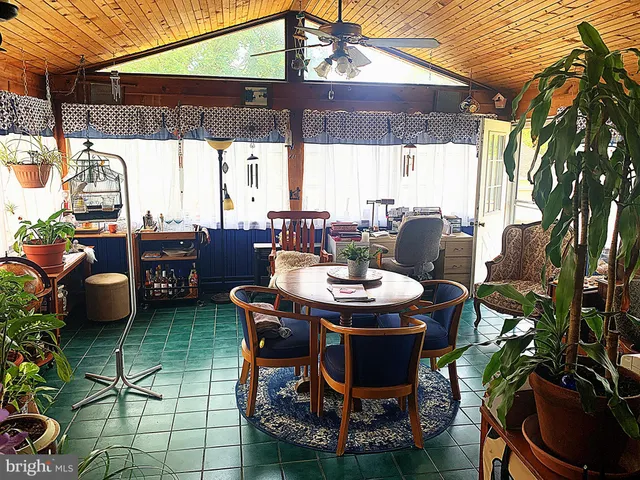 a patio table and chairs with potted plants