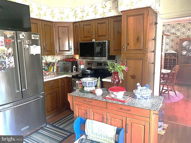 a kitchen with stainless steel appliances granite countertop a refrigerator and a stove