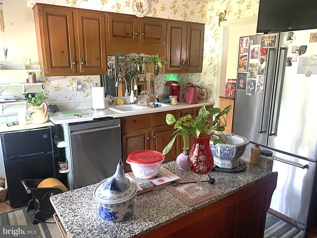 a kitchen with stainless steel appliances granite countertop a sink refrigerator and cabinets