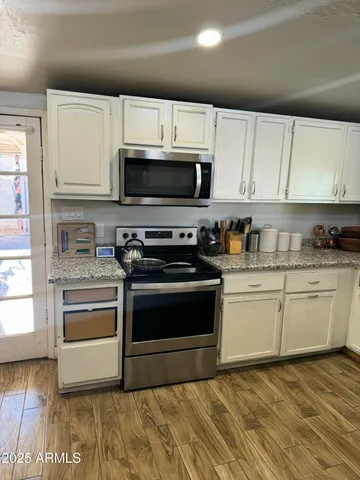 a kitchen with stainless steel appliances granite countertop a stove a sink and a microwave