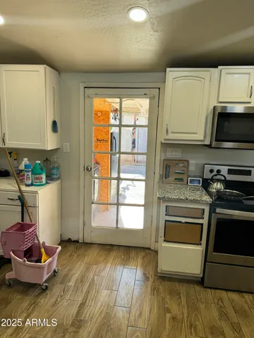 a kitchen with kitchen island granite countertop a stove and a wooden floor
