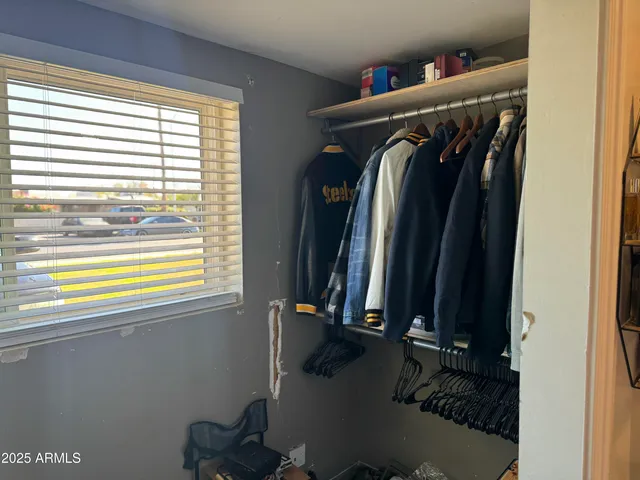 a view of walk in closet with clothes and shoes