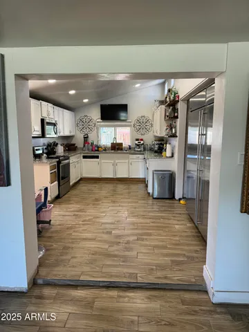 a large kitchen with kitchen island a large counter top space a sink stainless steel appliances and cabinets