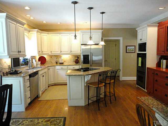 1108 Mersey Lane Raleigh, NC 27615 - Photo 5 of 25 a kitchen with stainless steel appliances granite countertop sink stove and wooden floor