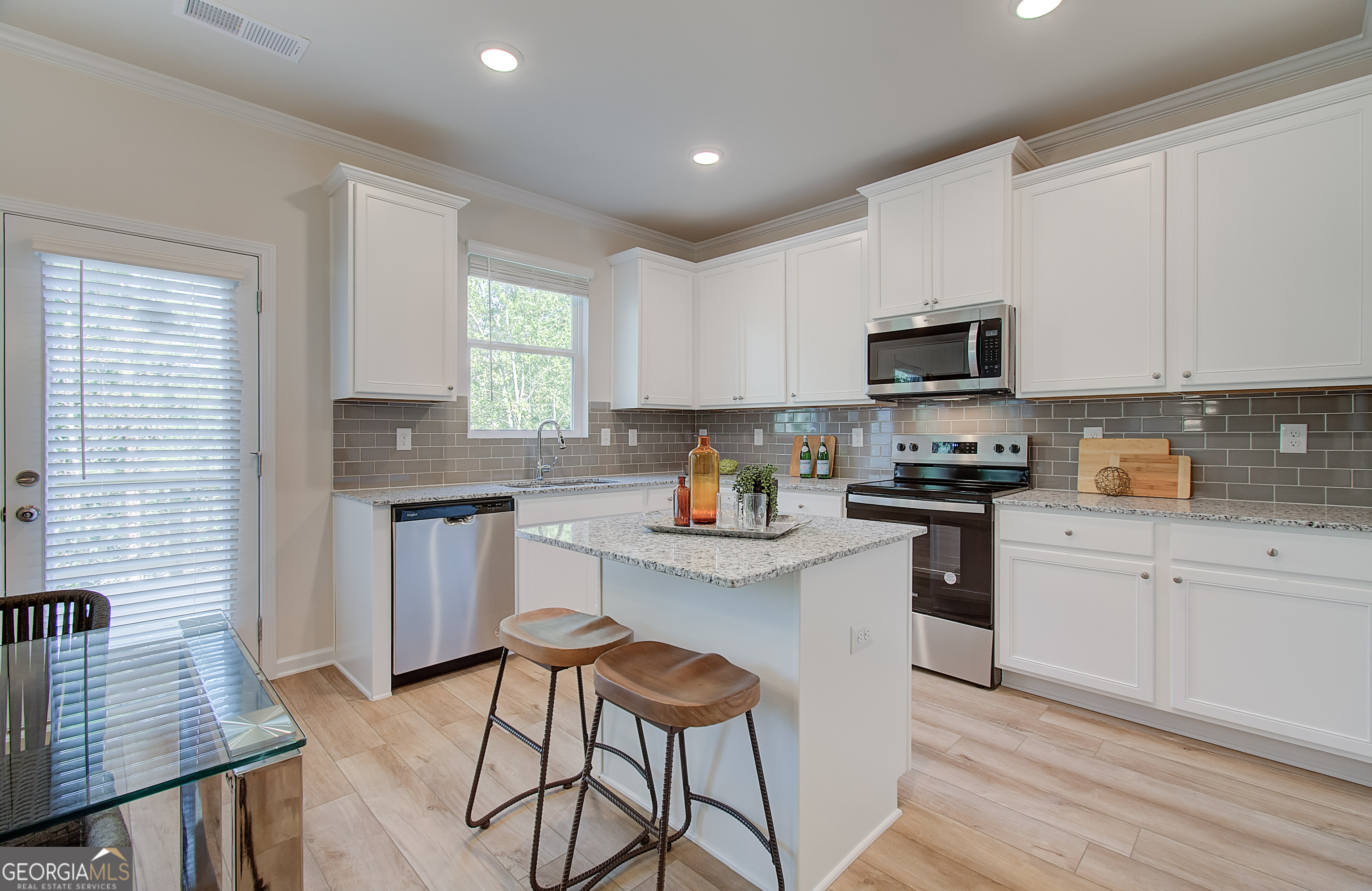 4581 Ajo Walk, Unit HOMESITE 22 Atlanta, GA 30331 - Photo 11 of 18 a kitchen with granite countertop a stove sink microwave and refrigerator