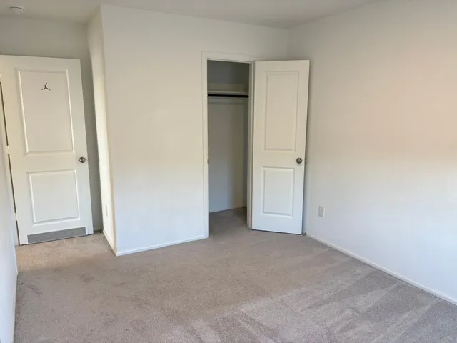 an empty room with windows and closet