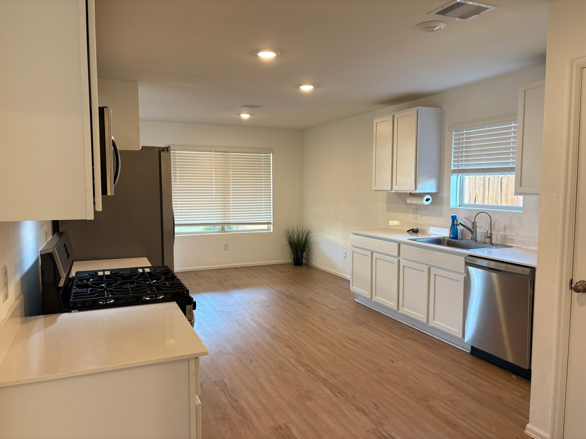 21911 Scopeto Lane New Caney, TX 77357 - Photo 7 of 14 a kitchen with a refrigerator a sink wooden floor and cabinets