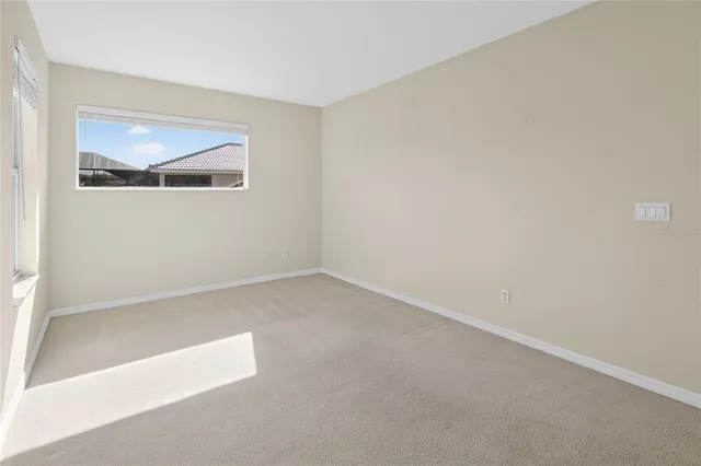 a dining room with furniture and a floor to ceiling window