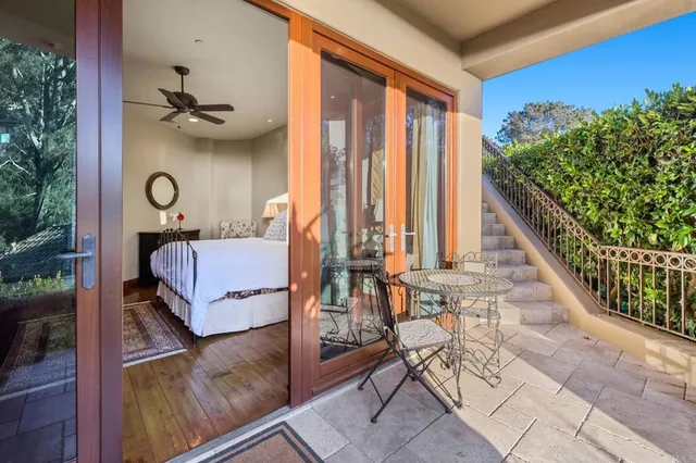 a view of a backyard with chairs under an umbrella