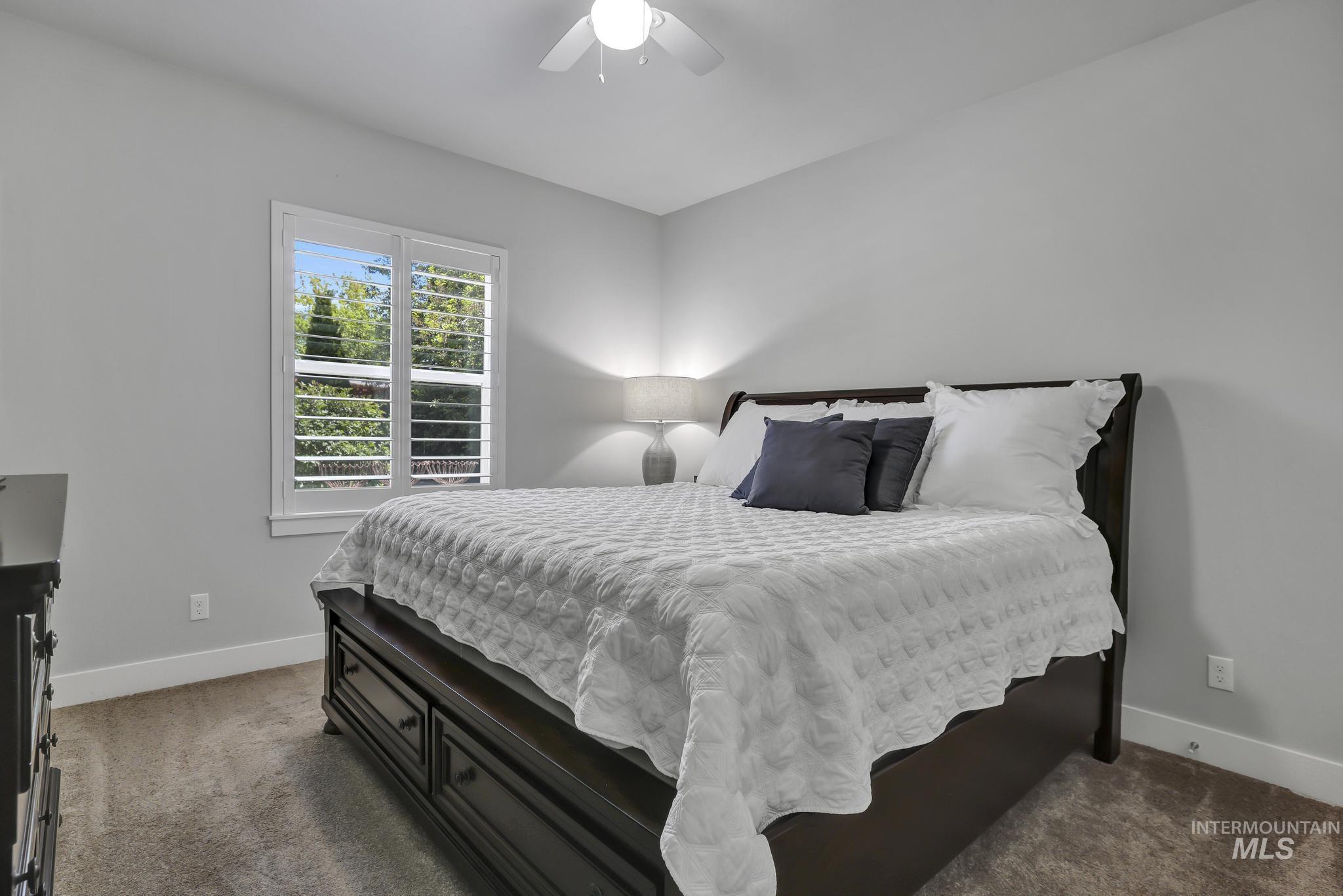 1937 Tamarack Loop Twin Falls, ID 83301 - Photo 27 of 50 Bedroom featuring a window with white plantation shutters, neutral gray wall paint, white trim, and gray carpet flooring