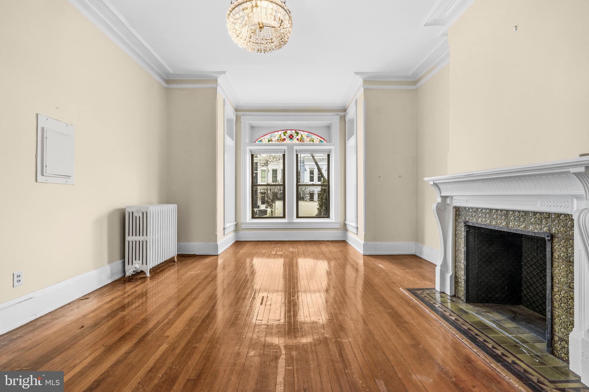 1920 11th Street Northwest Washington, DC 20001 - Photo 4 of 55 a view of an empty room with wooden floor fireplace and a window
