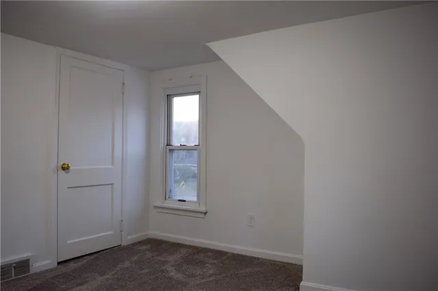 a view of small space with wooden floor and white walls