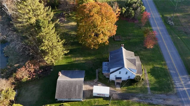an aerial view of residential houses with outdoor space and trees