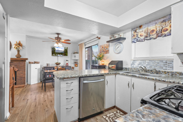 1120 Canyon Road, Unit 38 Ogden, UT 84404 - Photo 12 of 24 Kitchen featuring a peninsula, black gas range, stainless steel dishwasher, light wood-style floors, and a ceiling fan