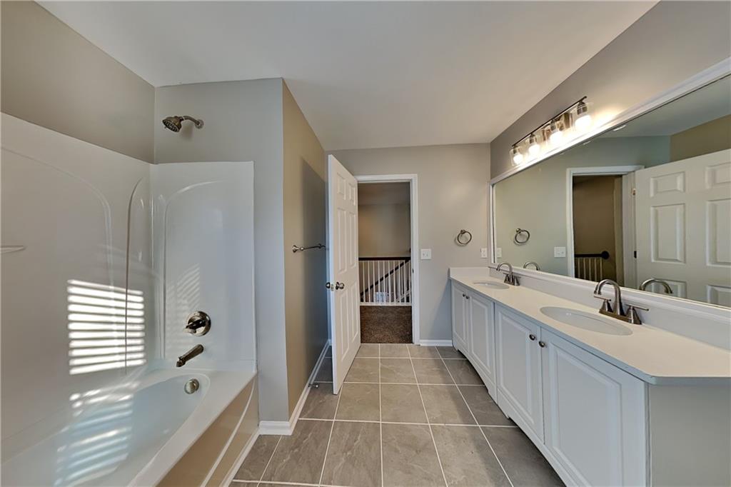 40 Parkmont Court Dallas, GA 30132 - Photo 16 of 19 a bathroom with a double vanity sink and mirror with shower