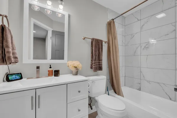 a bathroom with a sink a toilet and shower