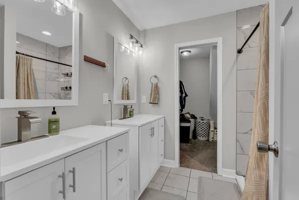 a bathroom with a double vanity sink mirror and shower