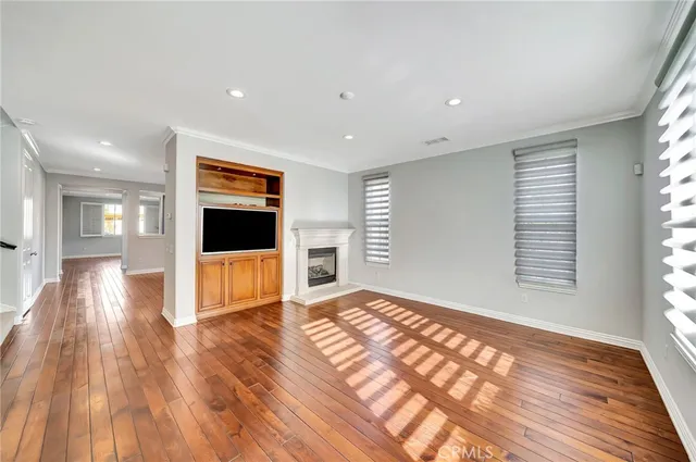 a kitchen with kitchen island granite countertop wooden floors and white cabinets