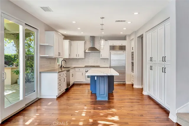 a kitchen with stainless steel appliances white cabinets and a stove top oven
