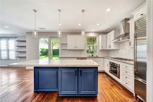 an empty room with wooden floor fireplace and windows