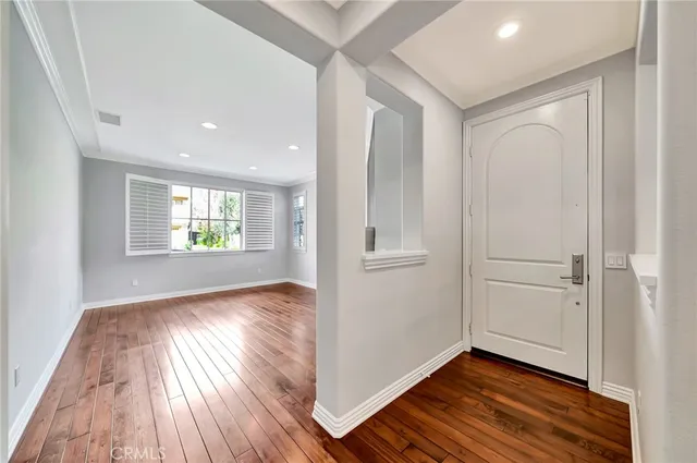 an empty room with wooden floor ceiling fan and windows