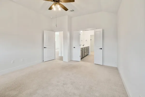 en empty room with a ceiling fan and window