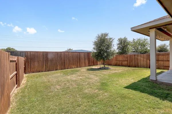 a view of a backyard with wooden fence